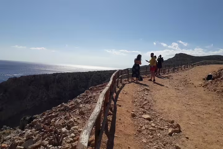 Visitors enjoy a scenic cliffside walk with stunning ocean views at Seitan Limania beach in Crete.