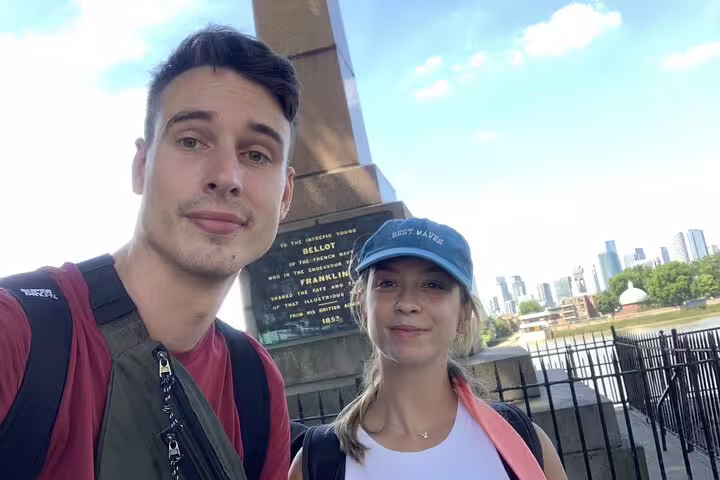 Couple taking selfie at Greenwich Franklin monument with London skyline in background
