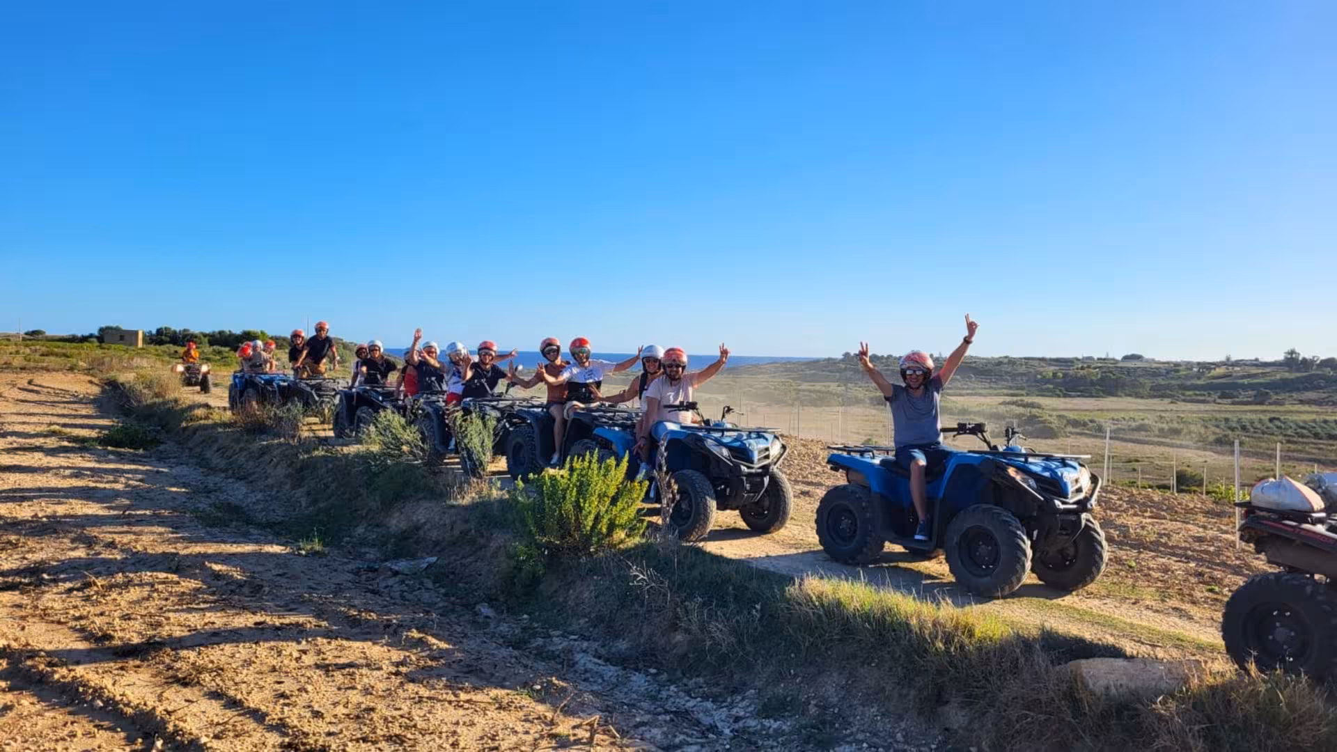 Group enjoying Selinunte 3-hour ATV tour through scenic Triscina dunes under clear blue sky.