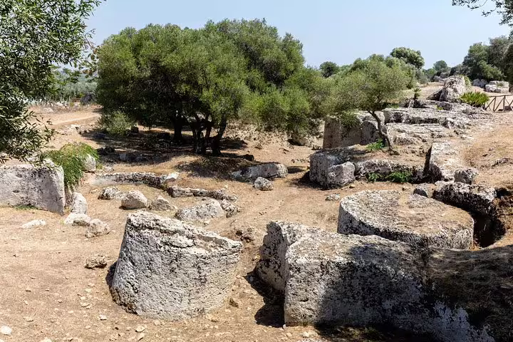 Ancient stone quarry remains and olive trees at Cave di Cusa, a historic stop on the Selinunte private tour from Palermo