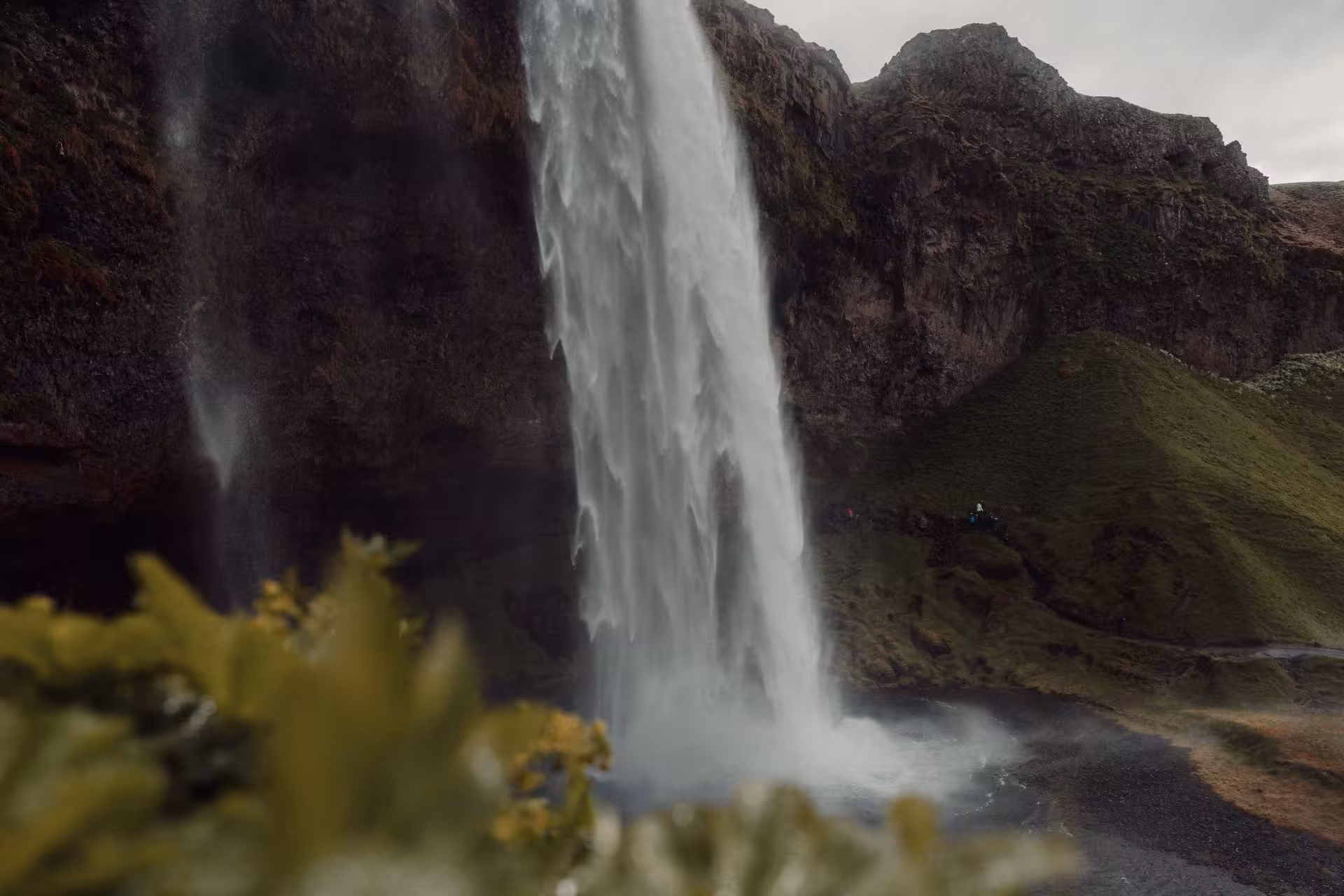 Powerful Seljalandsfoss waterfall cascading down volcanic cliffs with green moss on Iceland's south coast