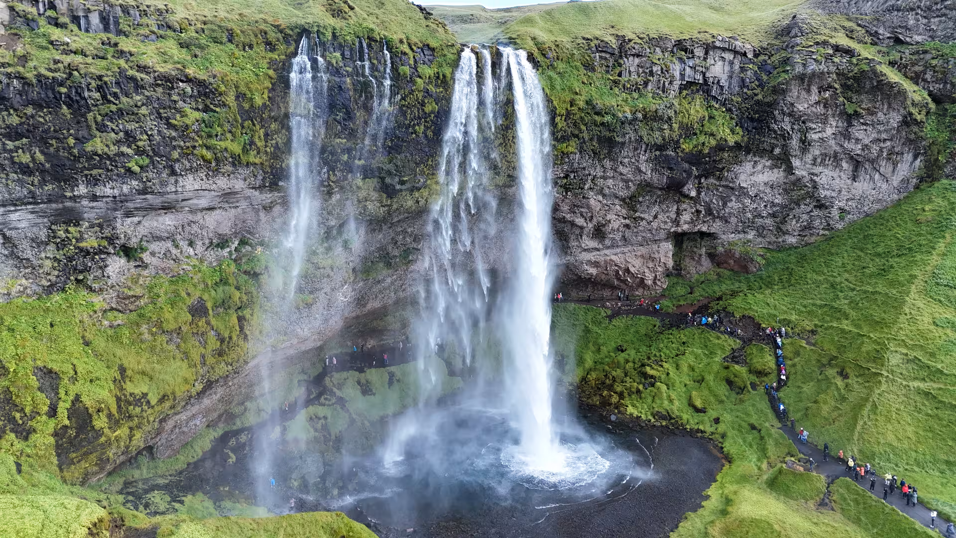 Aerial view of Seljalandsfoss waterfall on Iceland's South Coast with tourists on pathway below