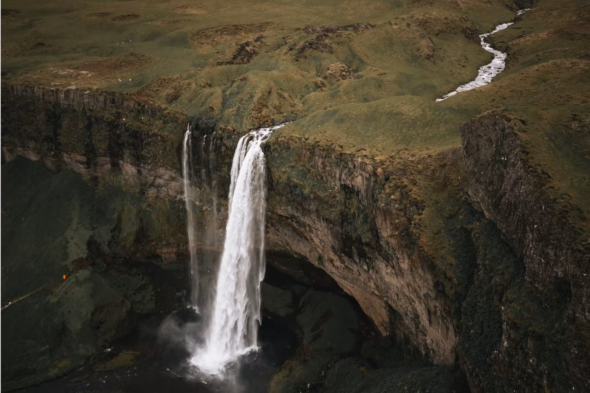 Aerial view of Seljalandsfoss waterfall cascading down mossy cliffs along Iceland's south coast