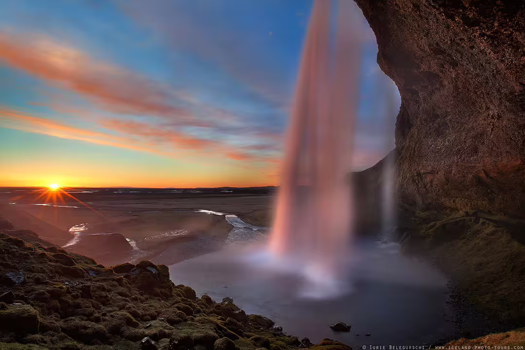 Stunning view behind Seljalandsfoss waterfall at sunset on Iceland South Coast day trip from Reykjavik