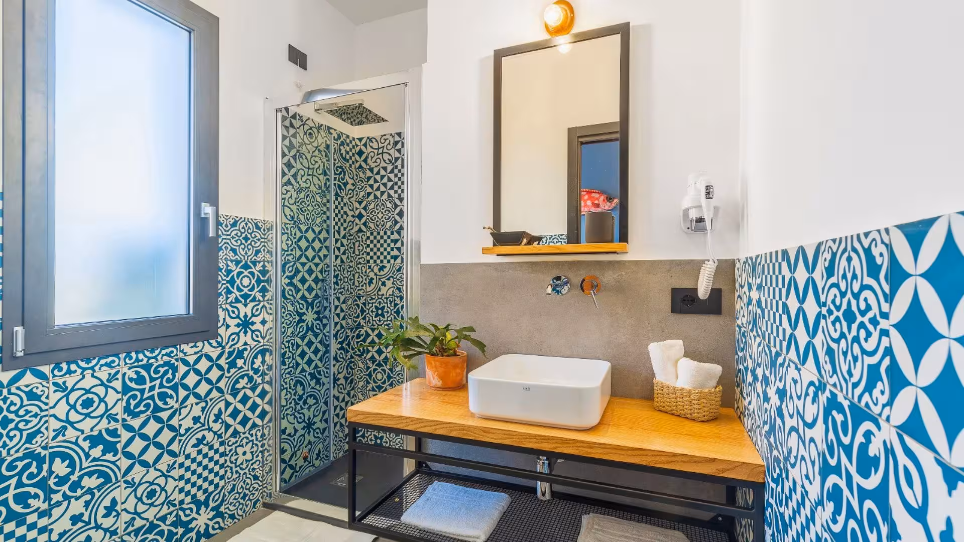 Stylish bathroom with patterned tiles and modern amenities, part of the accommodations on the Selvaggio Blu trek from Arbatax.