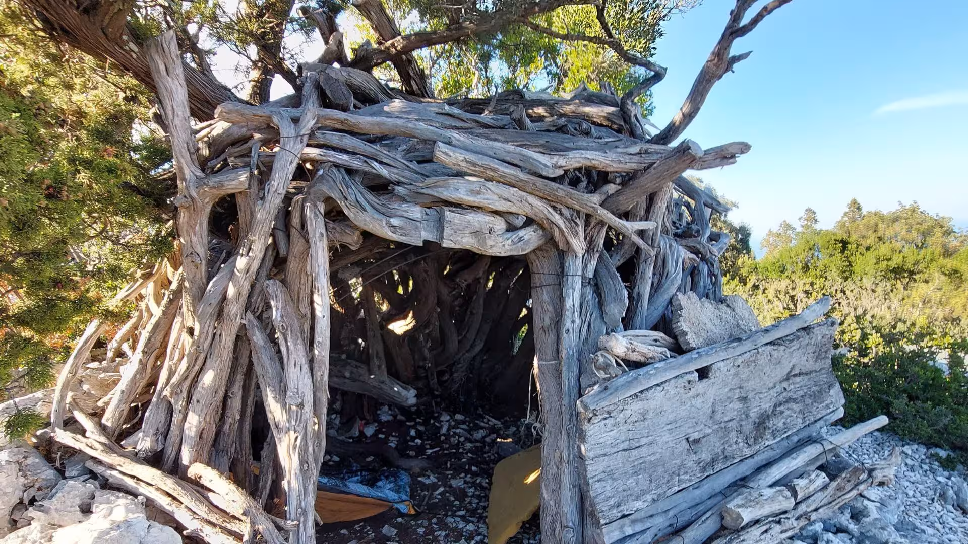 Rustic wooden shelter in Sardinia's Selvaggio Blu trek, blending nature with tradition and adventure.