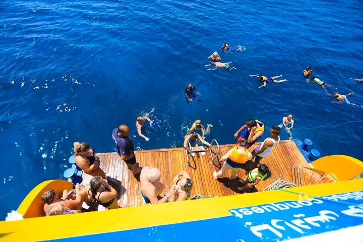 Guests snorkeling from a semi-submersible boat in Hurghada, exploring Red Sea reefs in clear blue water