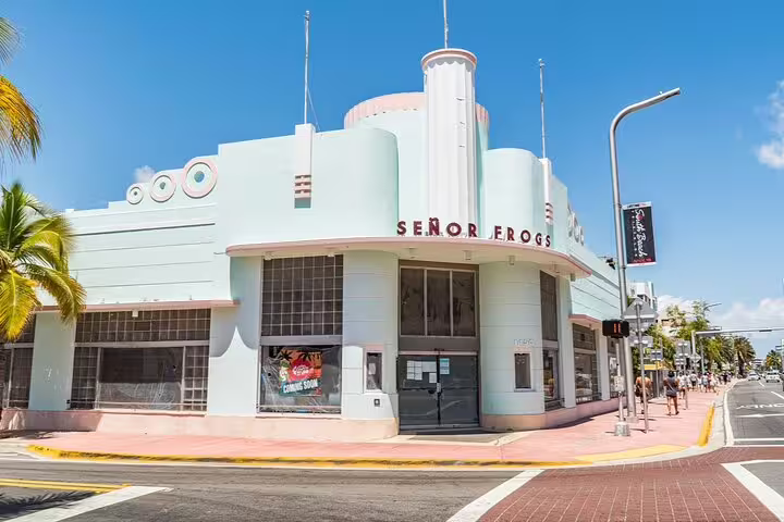 Señor Frogs Art Deco building on Miami Beach corner, pastel green facade under blue sky
