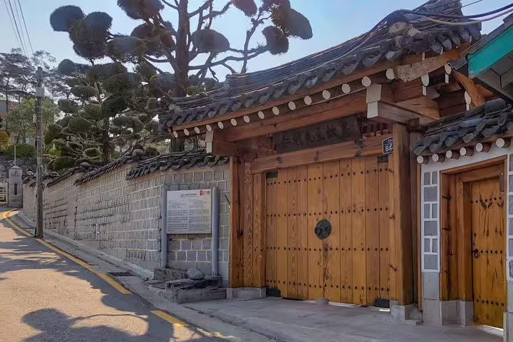 Traditional Korean hanok gate with wooden doors and tiled roof in Seoul neighborhood