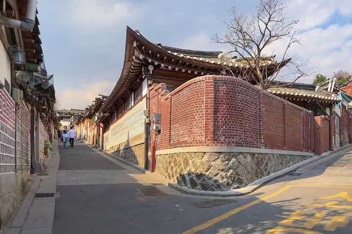 Narrow alley lined with traditional Korean hanok walls and curved brick gate in Seoul