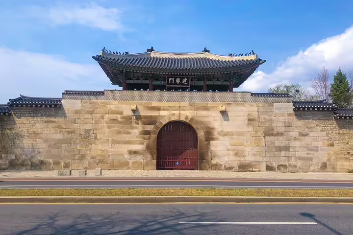 Historic건춘문 gate with traditional Korean pavilion roof and stone wall in Seoul