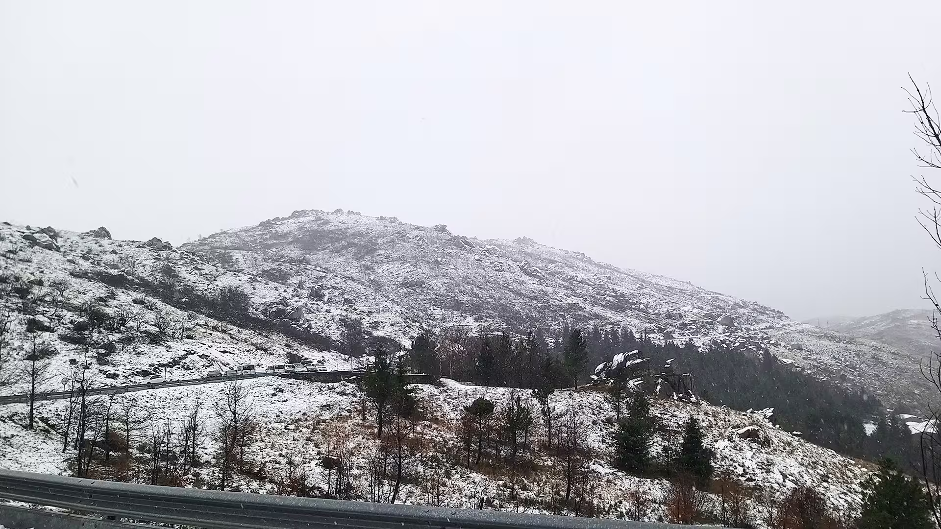 Snow-dusted hills and winding roads in Serra da Estrela Park, highlighting a scenic tour with famous regional cheese tasting.