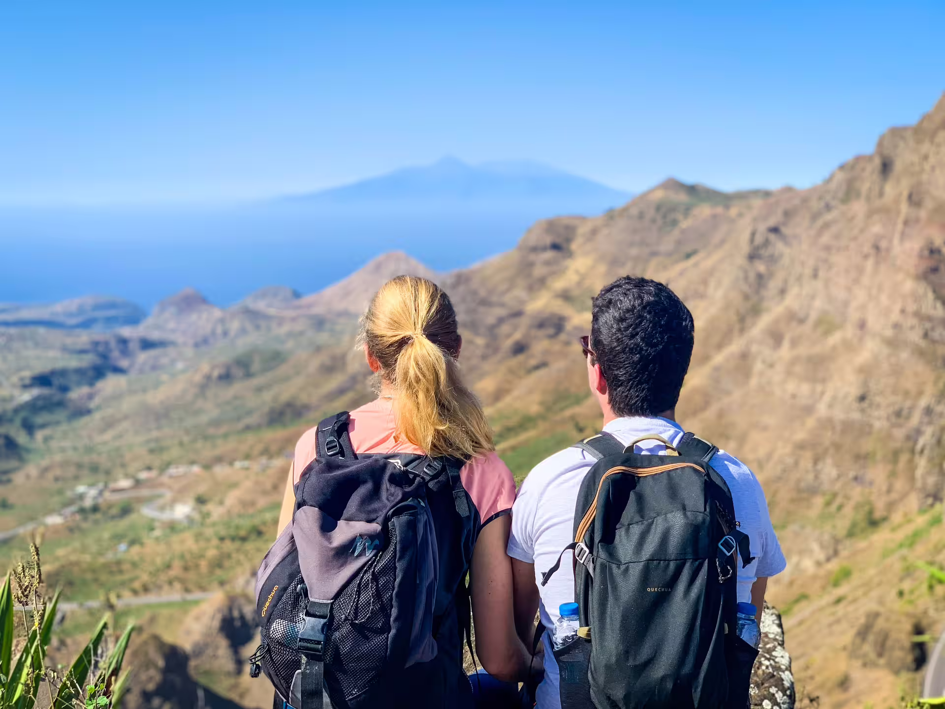 Couple enjoying panoramic views during Serra Malagueta hike with distant mountains and blue sky backdrop.