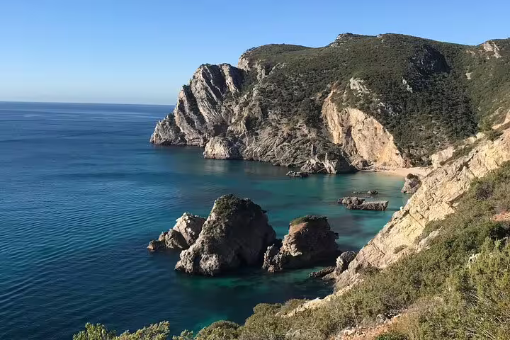 Stunning coastal cliffs and turquoise waters of Arrábida Natural Park, ideal for a small group kayak tour near Sesimbra.