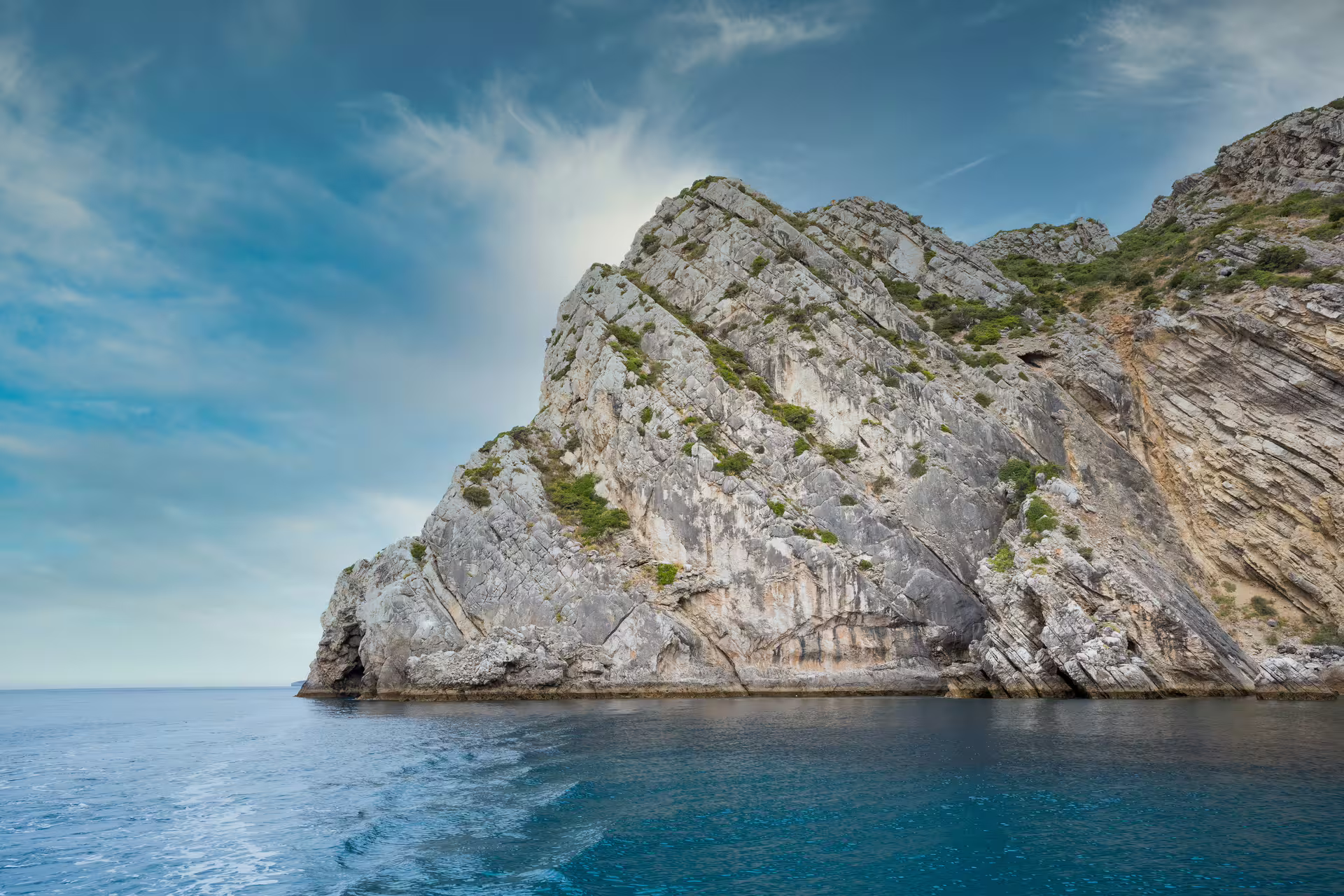 Dramatic cliffs and clear blue waters of Sesimbra's Arrábida Park, perfect for a scenic private boat tour adventure.