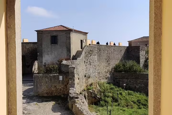Stone fortress walls and historic buildings in Sesimbra, Portugal, featured on a private day tour from Lisbon with wine tastings.