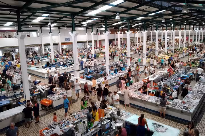 Bustling fish market in Setúbal filled with vendors and visitors, showcasing local culture on a private tour.