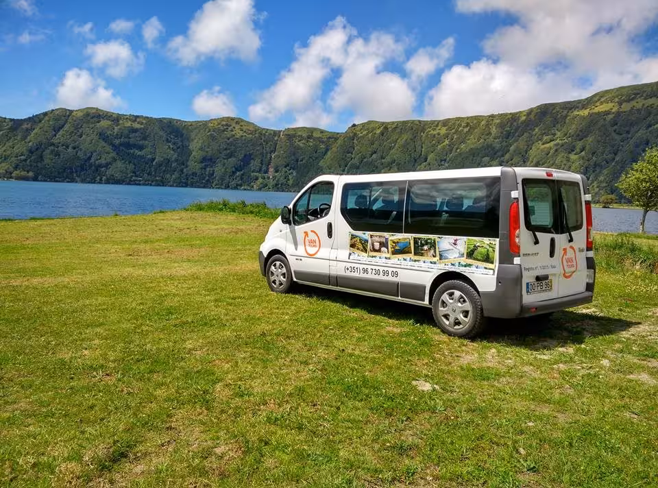 Comfortable sightseeing van parked by Sete Cidades lagoon on São Miguel island, offering scenic Azores lake tour