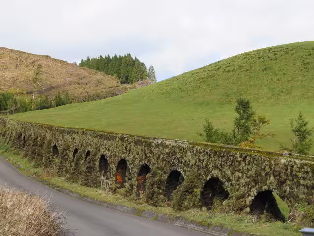 Historic moss-covered aqueduct beside a rural road on the Sete Cidades Jeep Tour and Serra Devassa hiking trail in São Miguel