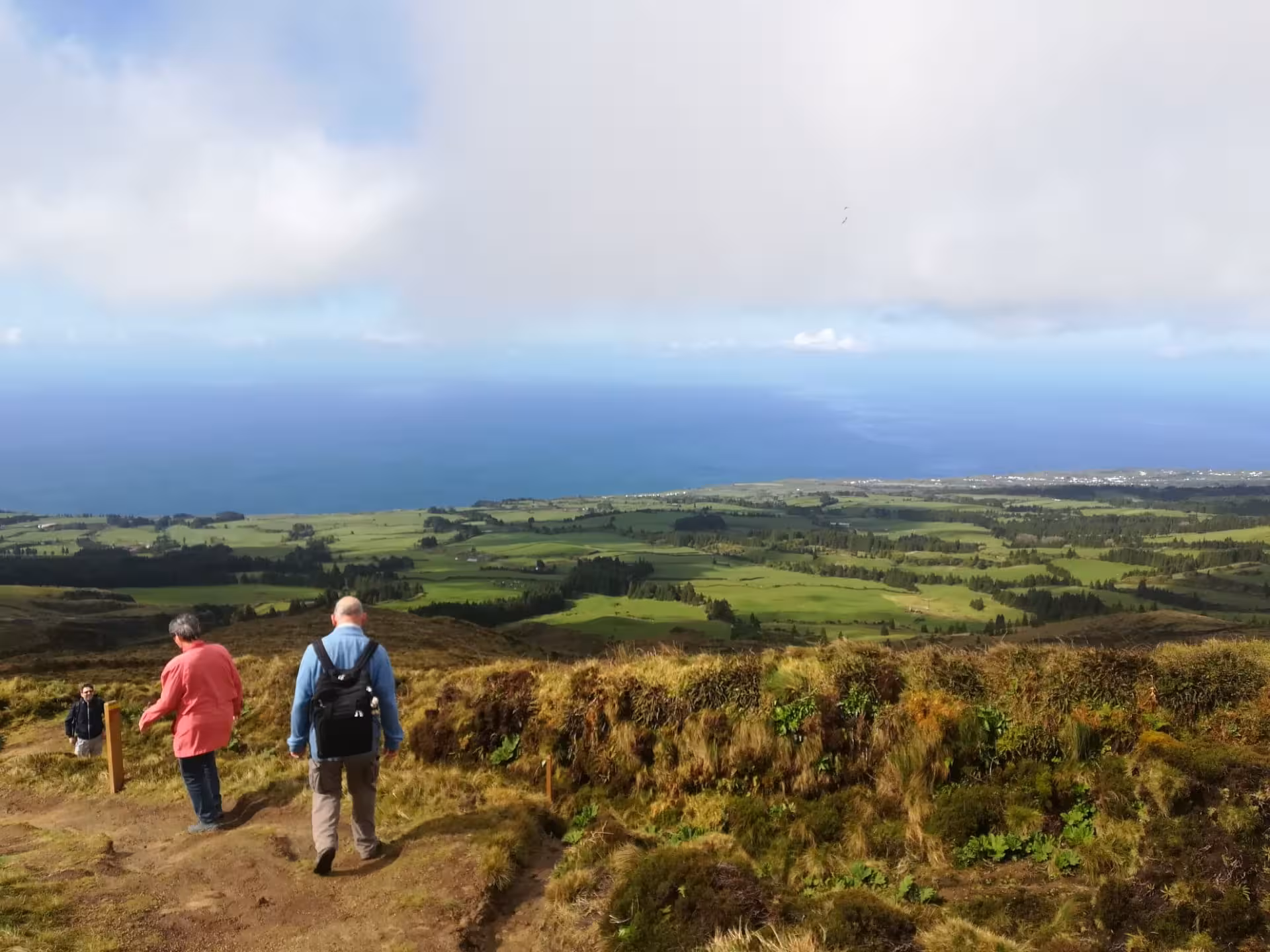 Walkers descending a scenic viewpoint above Sete Cidades on the Seven Cities half-day walking tour, Azores coast views
