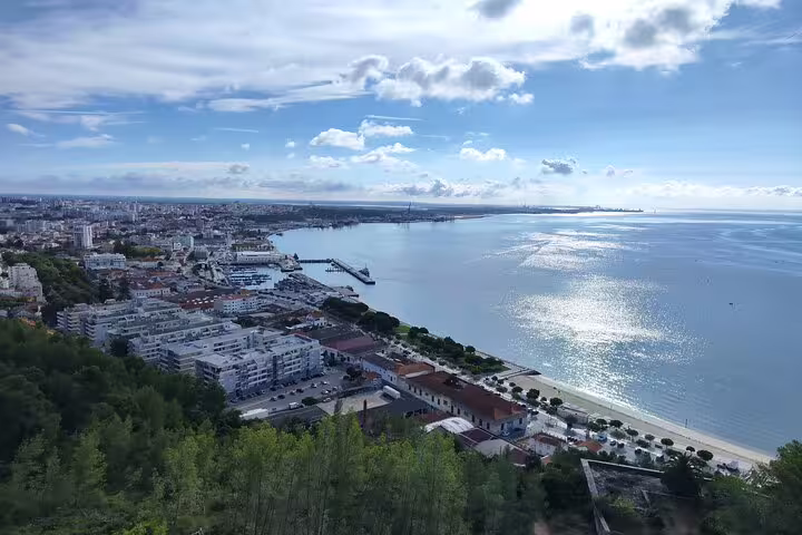 Aerial view of Setúbal's coastline with sparkling waters and urban landscape, ideal for cultural and seaside exploration.