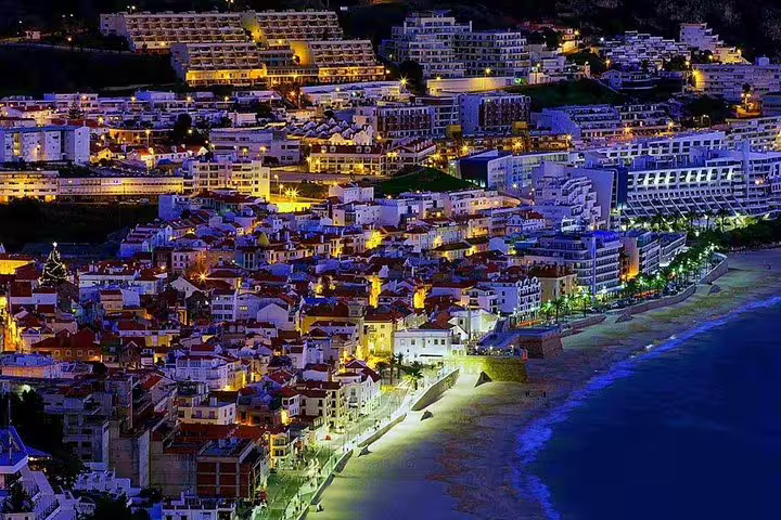 Scenic night view of Setúbal's illuminated coastline and charming architecture, ideal for private tours exploring Arrábida's beauty.