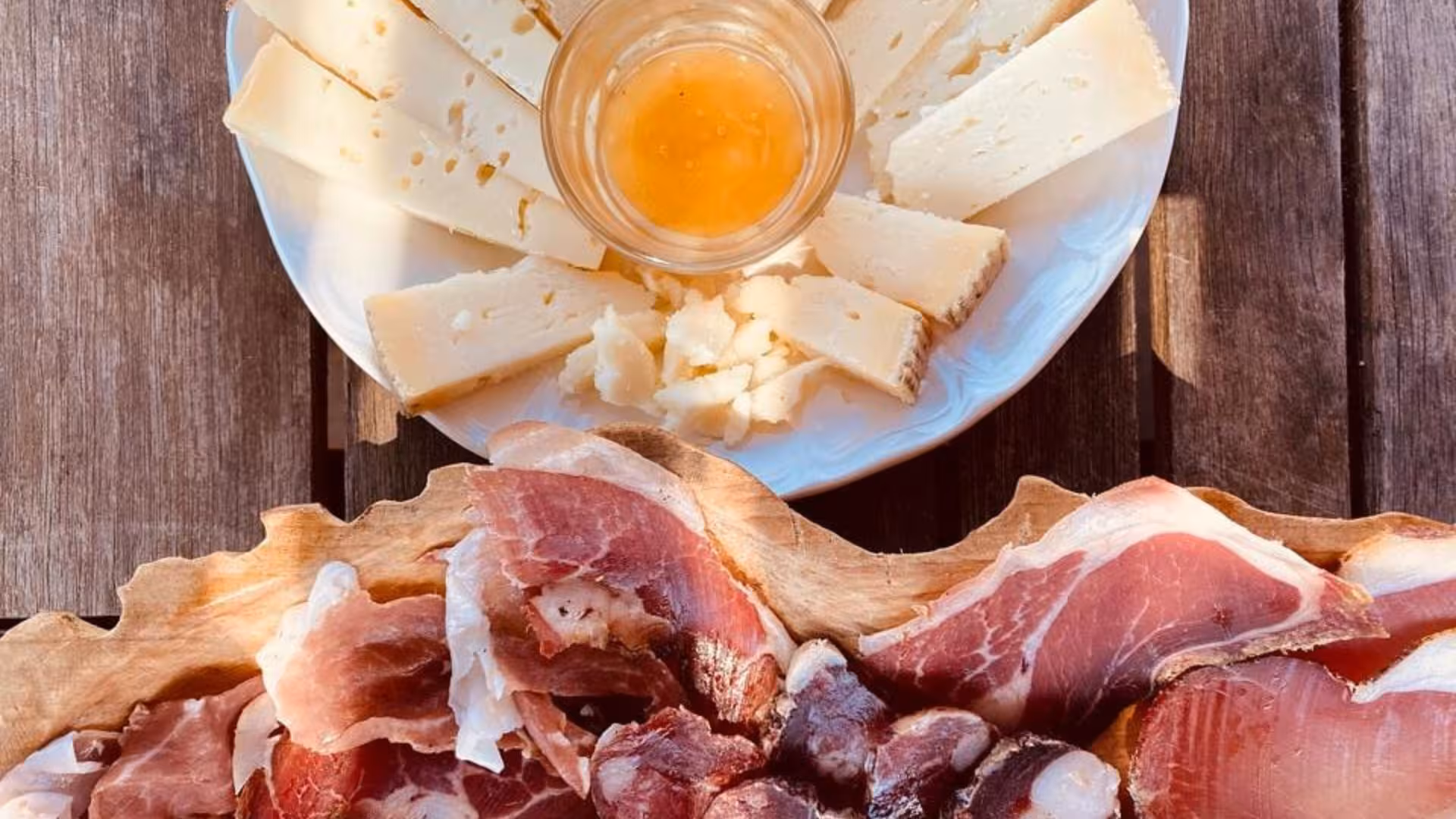 A rustic platter featuring cured meats and Sardinian cheese, perfect for tasting on a Seulo farm tour.