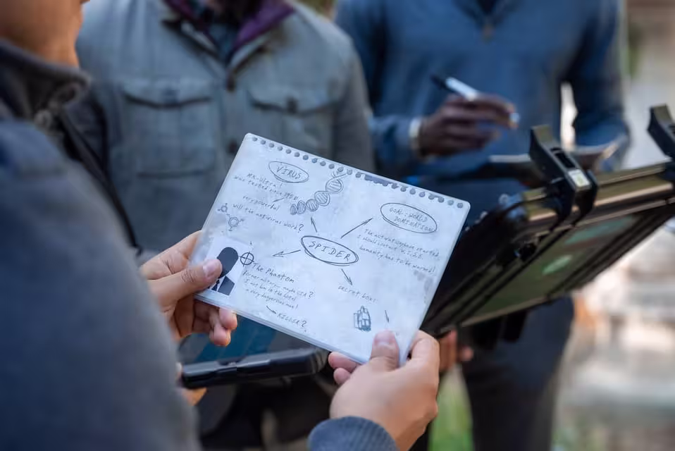 Team reviews hand-drawn notes to crack codes in Seville's immersive BlackOut escape game experience.