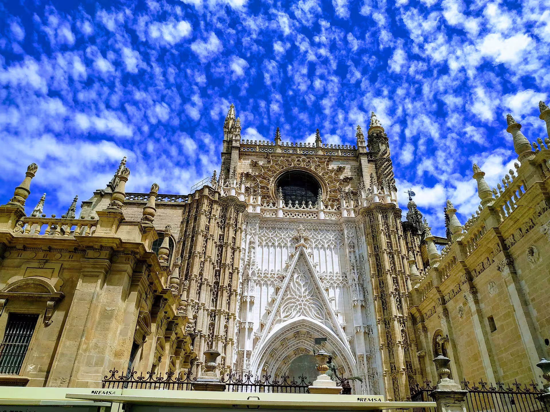 Seville Cathedral Gothic facade on Costa del Sol pick-up group tour, ornate stonework under bright blue sky