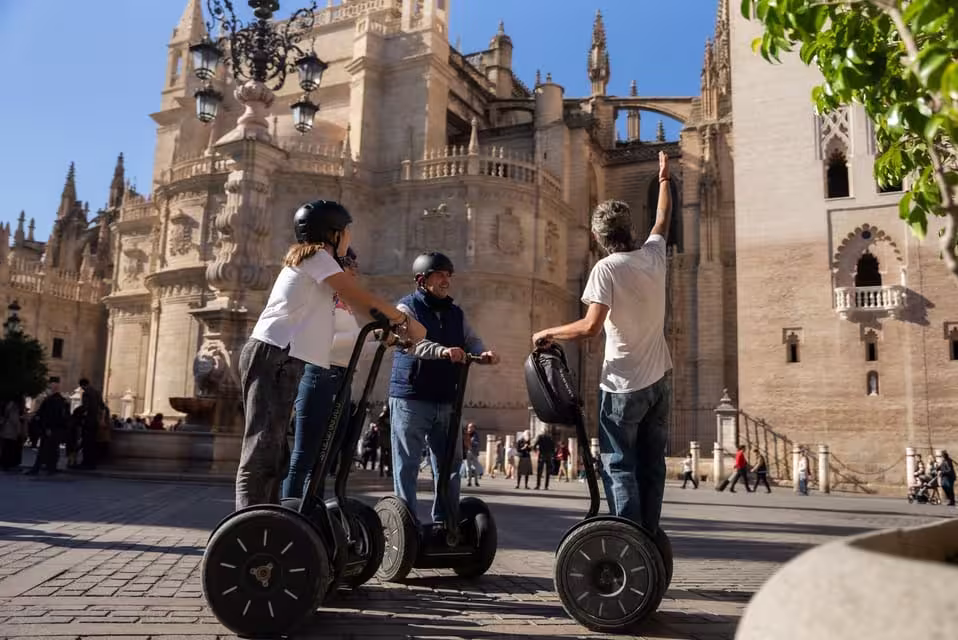Visitors on Segways admire the stunning architecture of Seville Cathedral during a guided tour.