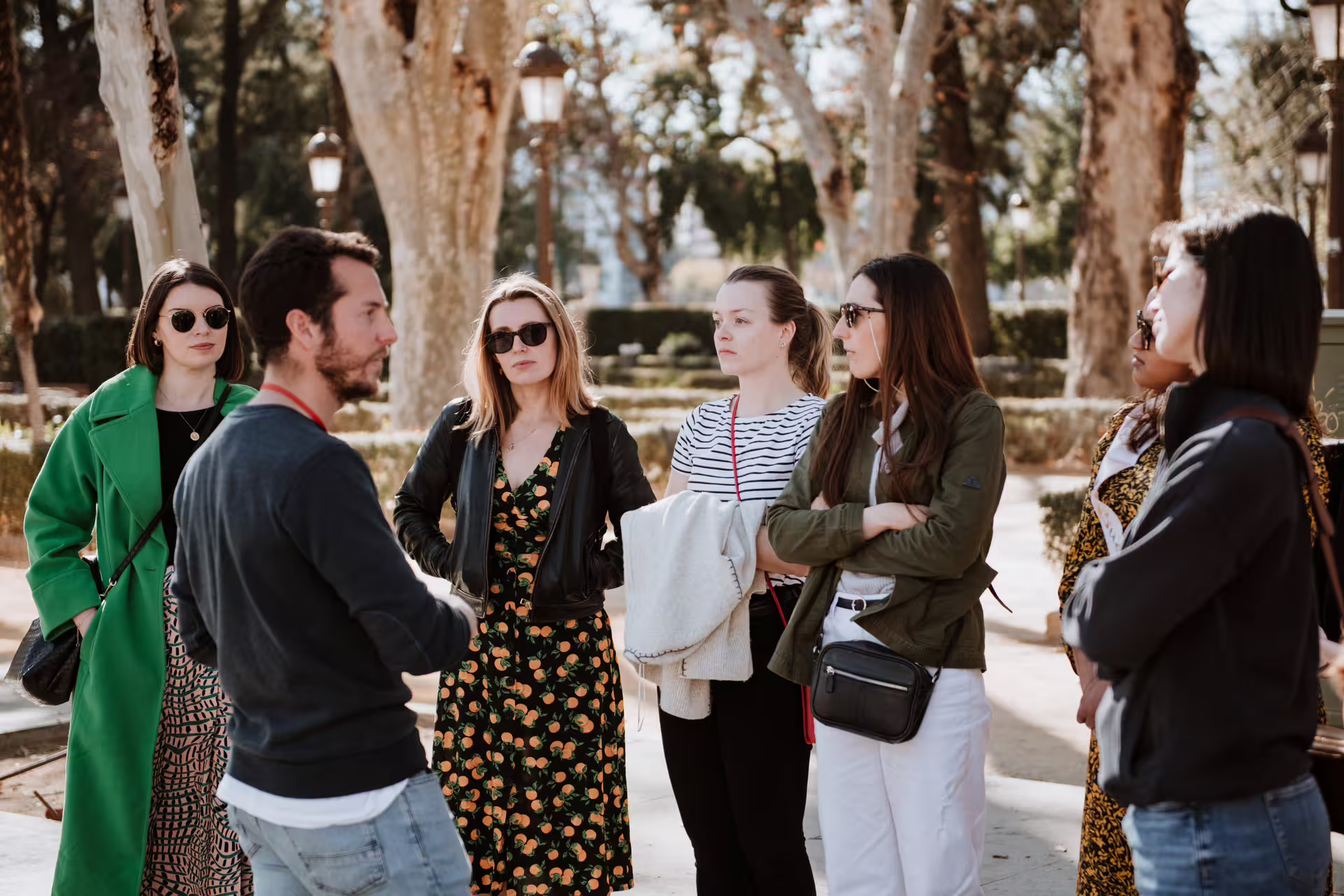 Group of tourists enjoying a guided walking tour in Seville, exploring historic sites and learning about local culture in small groups.