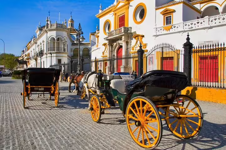 Horse-drawn carriages outside Seville's vibrant historic architecture, perfect for cruisers on the Alcazar skip-the-line tour.