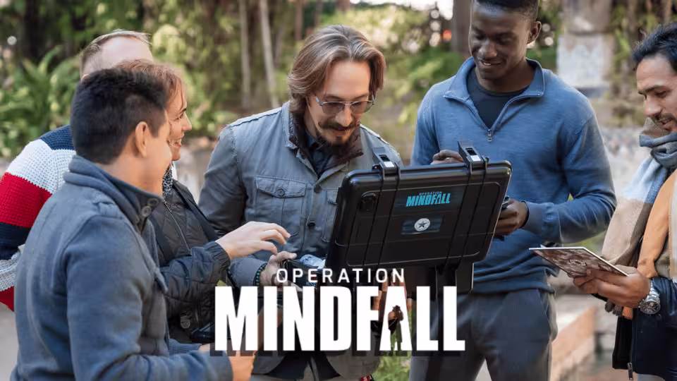 A group engaged in Seville's Operation Mindfall outdoor escape game, collaborating with a tablet for clues and fun.