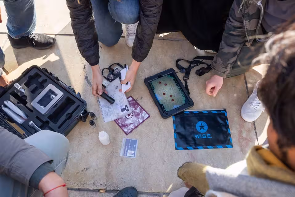Participants examine clues and gadgets during the Seville outdoor escape game BlackOut hard mode.