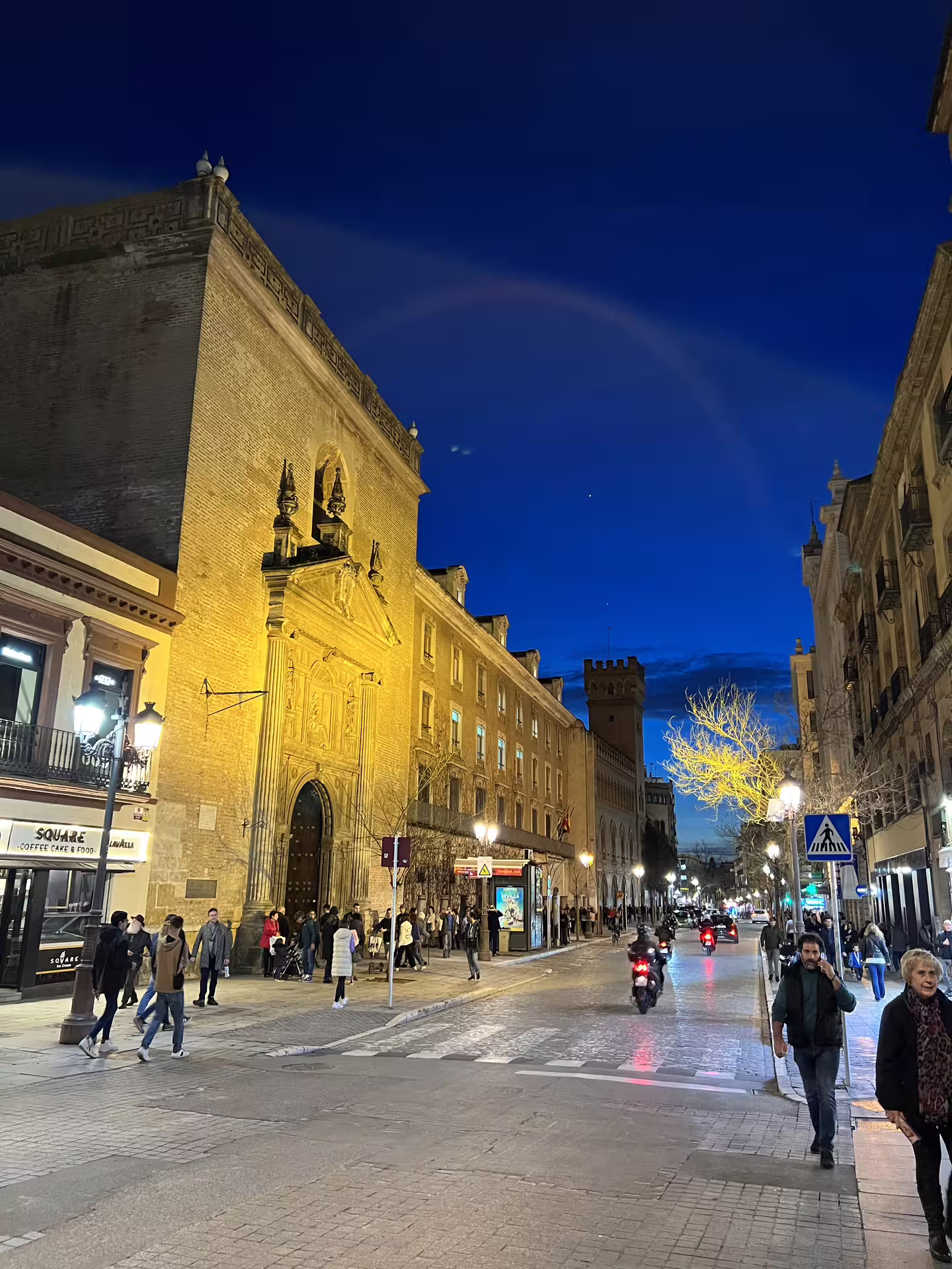 Nighttime street scene in Seville with historic architecture and lively atmosphere, perfect for a mysterious paranormal tour.