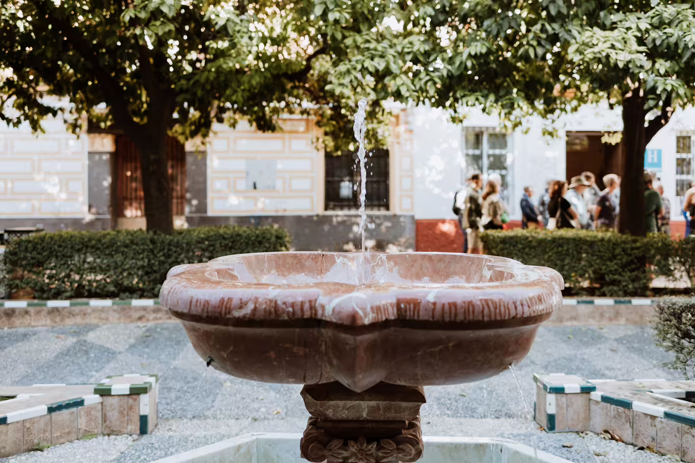 Charming fountain in a lush courtyard of Seville's Santa Cruz, Jewish Quarter tour highlights.