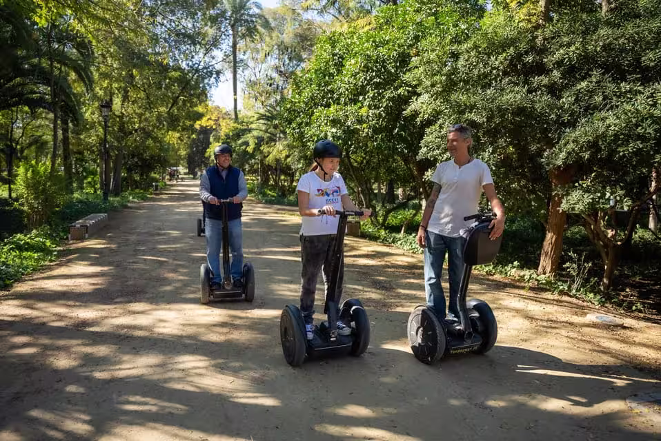 Participants riding Segways through a lush, green path during a historical tour in Seville.