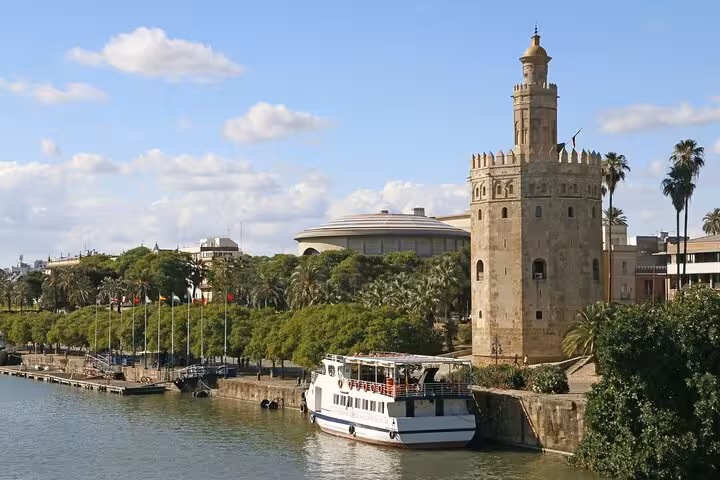 Explore Seville's iconic Torre del Oro along the Guadalquivir River on a 5-day Andalusia tour from Madrid.