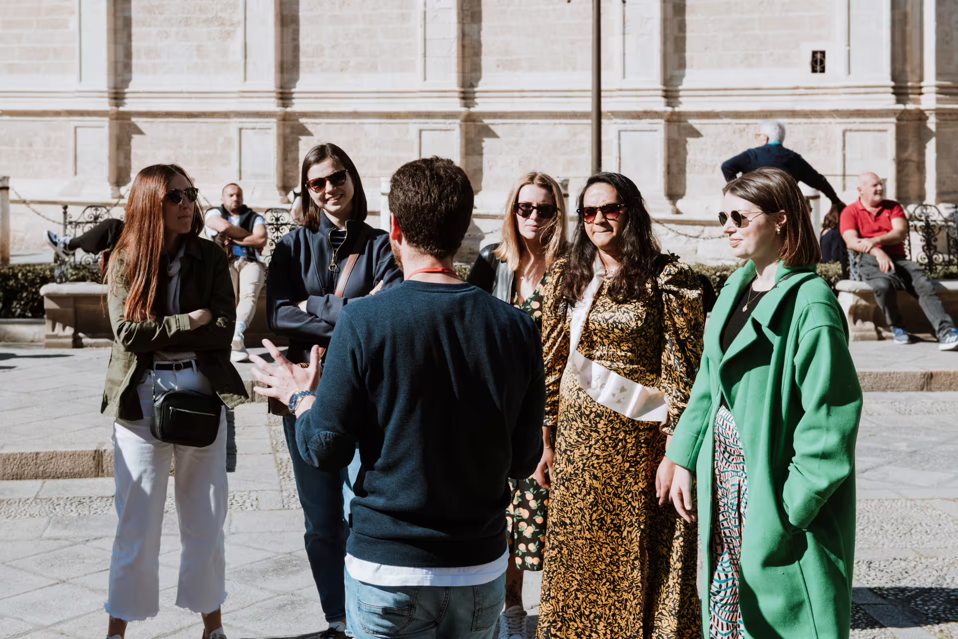 Tour guide leads small group through historic Seville, offering an immersive and personalized walking tour experience in Spain.