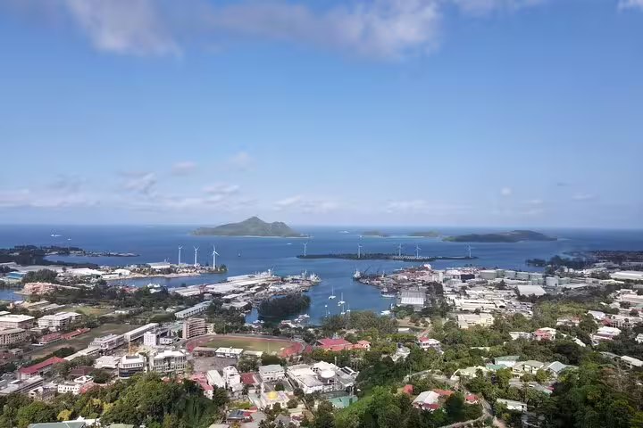 Scenic aerial view of Seychelles coastline and cityscape, showcasing ocean access for airport and hotel transfers.
