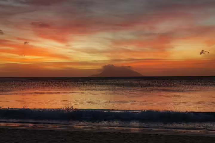 Stunning Seychelles sunset over a tranquil ocean, ideal for a private island tour experience.