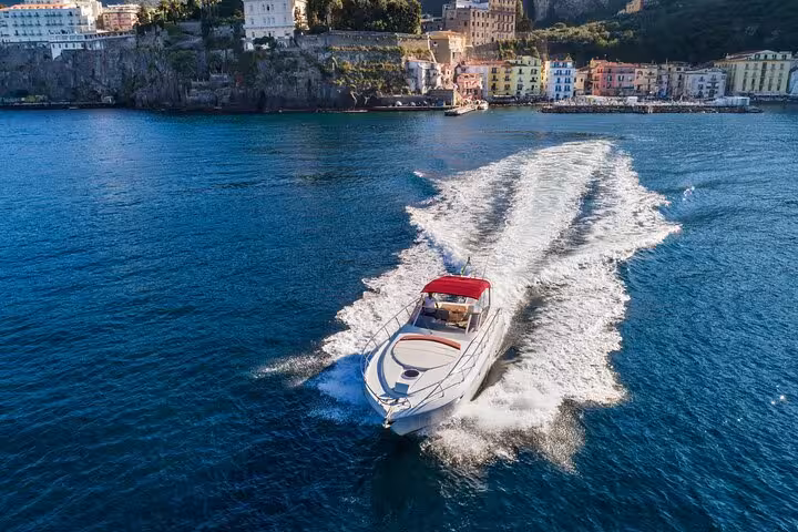 Elegant Shamal 40 yacht sailing towards picturesque Positano, showcasing luxury travel from Sorrento to Capri.