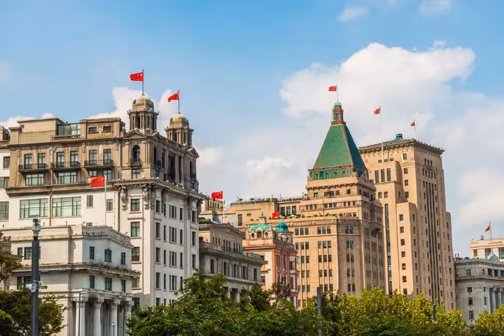 Historic colonial-era buildings along the Bund in Shanghai with Chinese flags flying