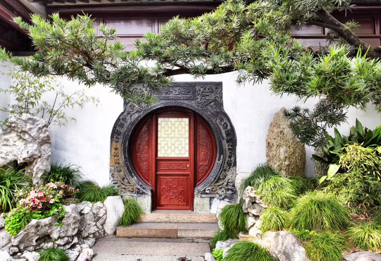 Traditional Chinese garden with a circular red door, perfect for exploring on a Shanghai private tour with guide.