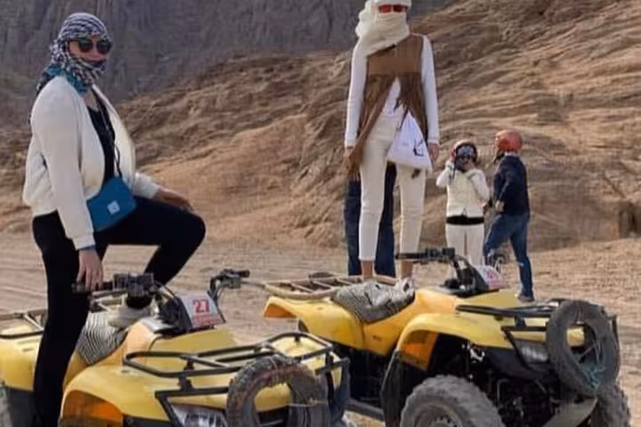 Guests pose on yellow quad bikes during Sharm El-Sheikh ATV safari, wearing scarves in Sinai desert