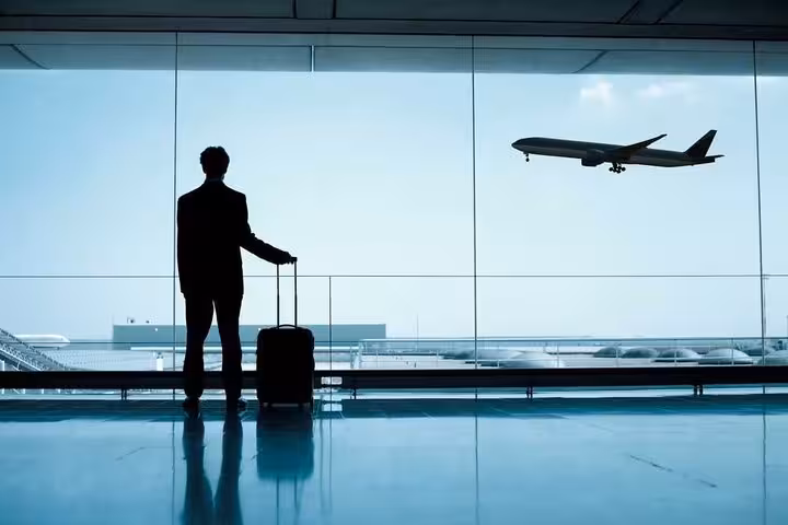 Traveler at airport window watching plane, fly from Sharm El Sheikh to Cairo for pyramids and GEM tour