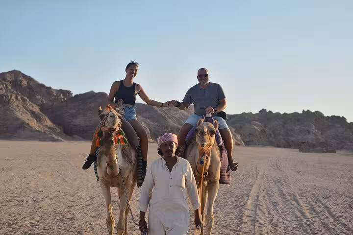 Couple riding camels in Sharm El Sheikh desert with Bedouin guide on mega safari waves and dunes tour