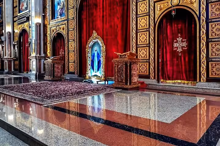 Ornate interior of a Sharm El Sheikh church with red curtains and icons, included on the Sharm city tour excursion