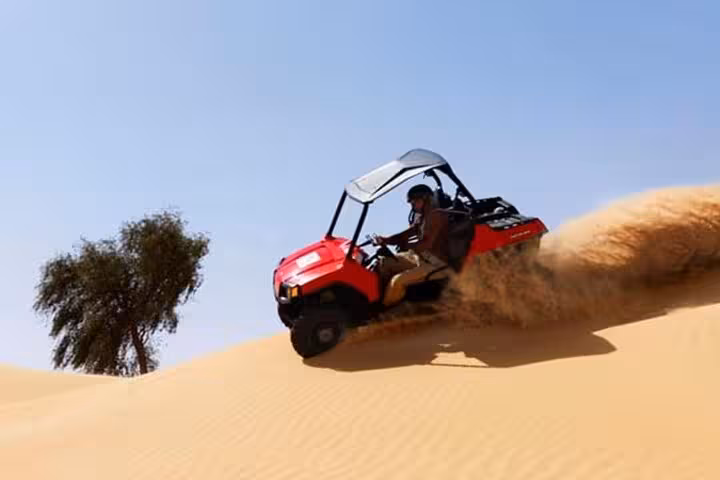 Driver descends a golden dune in Sharm El-Sheikh on a desert buggy safari adventure across the Sinai sands