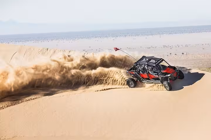 Off-road buggy drifts on Sinai sand dunes in Sharm El-Sheikh desert safari adventure, kicking up dust